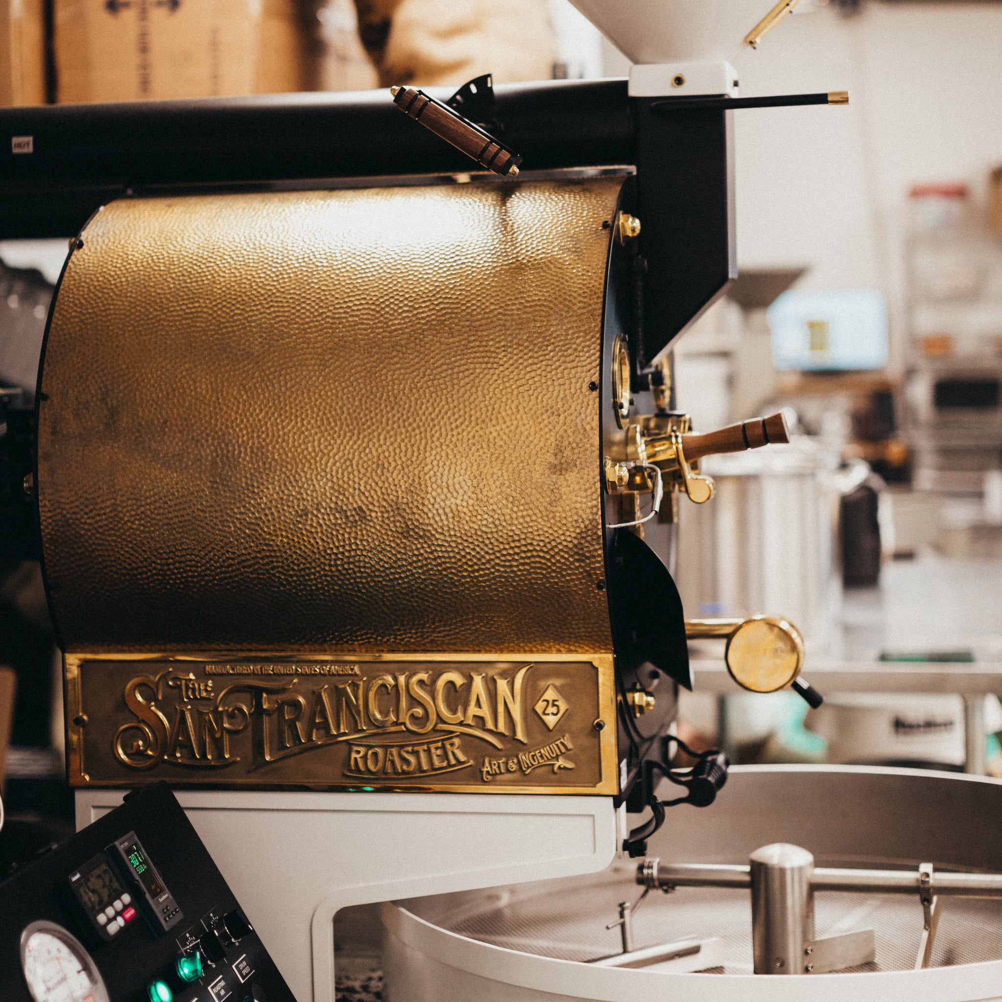 Gold coffee roaster with 'San Francisco Roaster' branding in a commercial kitchen setting